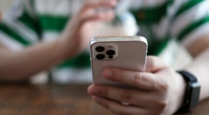 a close up of a person holding a cell phone